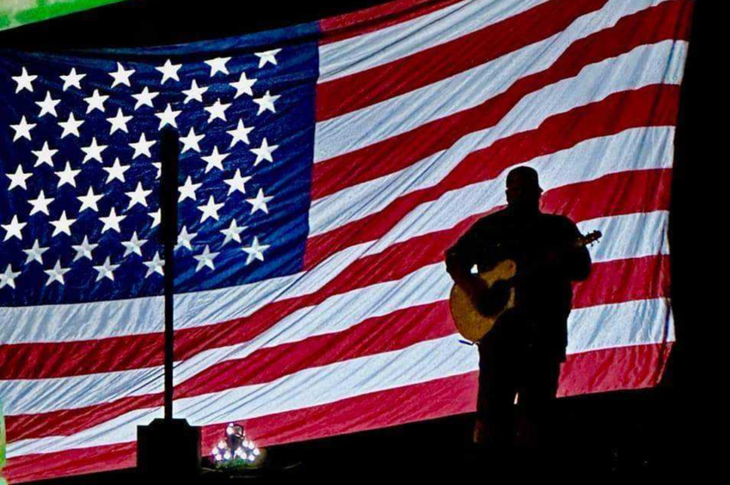 Canaan James in front of American Flag