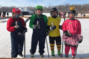 Kids posing with their trohpies at the pond hockey tournament wearing Mario brothers themed costumes