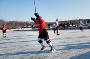 Southern Minnesota Pond Hockey Tournament in Fairmont view of hockey player cheering on the rink on Lake Sisseton