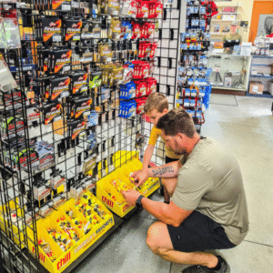 Family looking at fishing supplies inside sommer outdoors