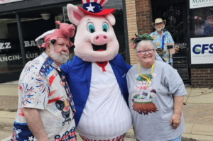 Happy Pig Collector couple posing with Marty the pig in Fairmont, minnesota