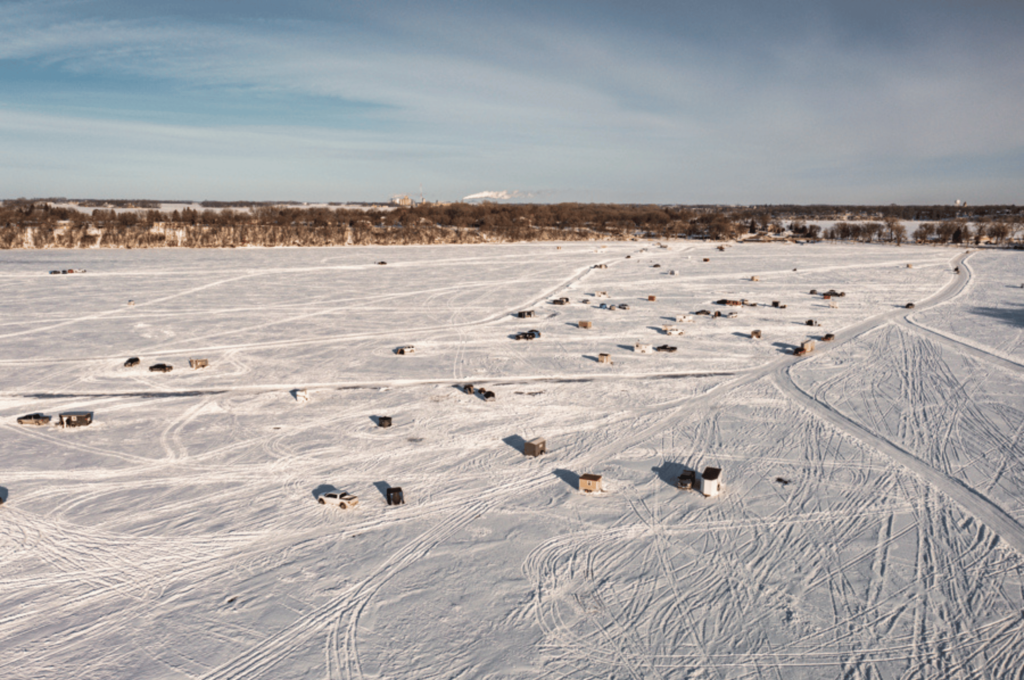 Winter Guide: Things to do in Fairmont. Aerial view of Fairmont's Lakes in the winter with ice houses on the lake