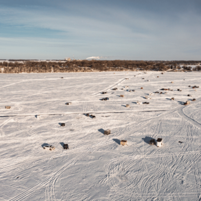 Winter Guide: Things to do in Fairmont. Aerial view of Fairmont's Lakes in the winter with ice houses on the lake