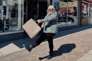 Girl shopping in downtown Fairmont posing with a shopping bag