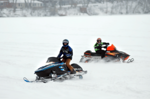 2 people snowmobiling on Fairmont's snowmobile trails