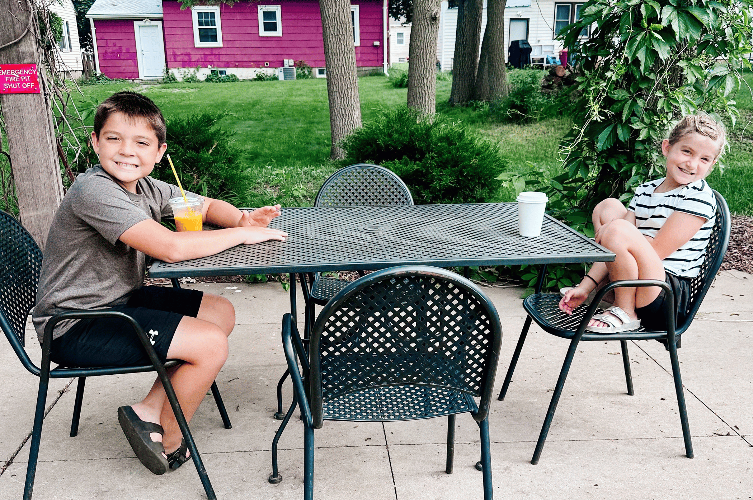 Two children sitting on the patio at Graffiti Corner in Fairmont, Minnesota, enjoying their coffee drinks.