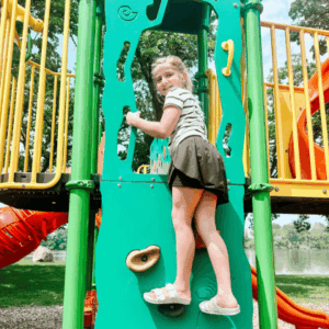 Girl playing on the playground at Sylvania Park in Fairmont, MN.