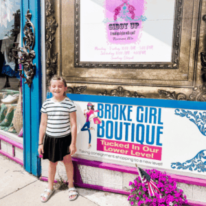 A girl standing in front of The Giddy Up Boutique in downtown Fairmont, Minnesota.