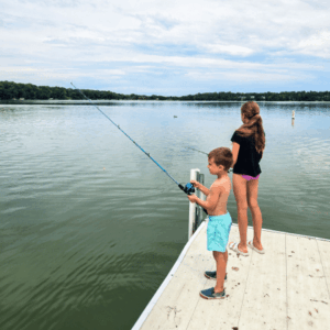 Two kids fishing on the dock at Lake Imogene at Flying Goose Campground and Resort in Fairmont, MN.