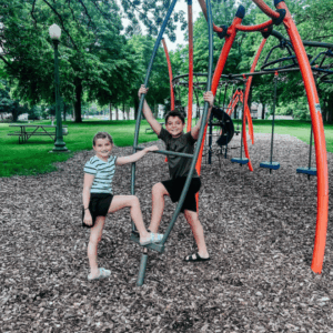 Two children playing on the playground at Ward Park in Fairmont, Minnesota