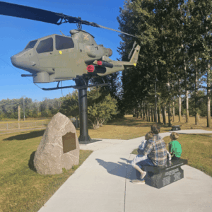 Family looking at the Bell Cobra-Rotary Wing Attack Helicopter, AH-1-66-F-15327 at the Martin County Veterans Memorial in Fairmont Minnesota