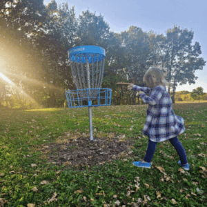 Girl at Cedar Creek Park playing Disc Golf in Fairmont, Minnesota